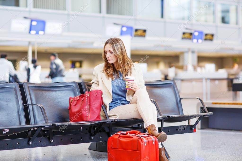 woman at international airport waiting for flight at terminal