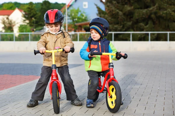 Two little siblings having fun on bikes in city on vacations — Stock Photo, Image