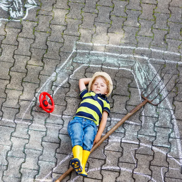Мальчик веселится с рисунком трактора мелом — стоковое фото