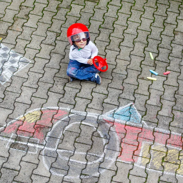 Little boy having fun with race car drawing with chalks — Stock Photo, Image