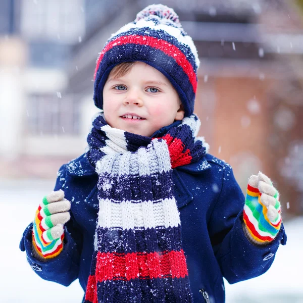 カラフルな冬の服を楽しんでかわいい面白い男の子 — ストック写真