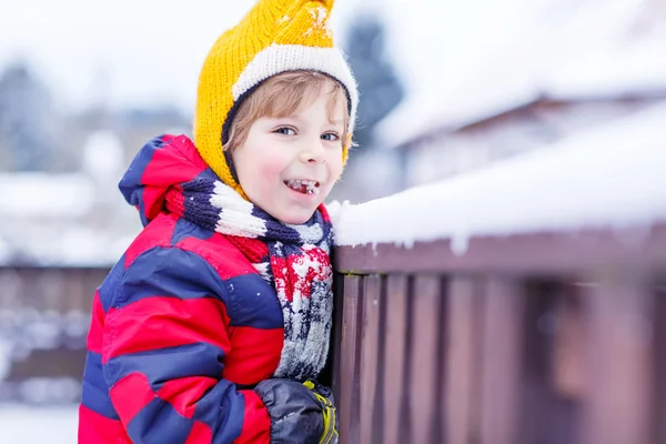 Little kid boy eating and tasting snow, outdoors on cold day — Stock Photo, Image