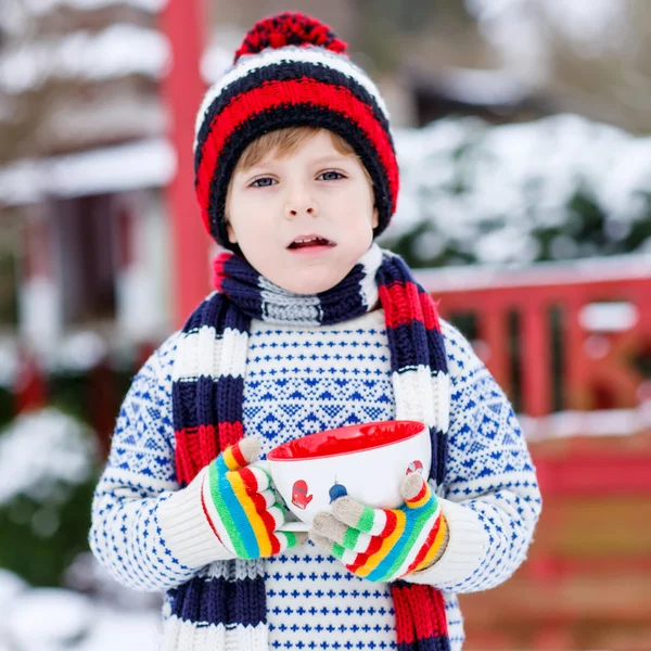 Amuzant copil mic care deține ceașcă mare cu fulgi de zăpadă și choco fierbinte — Fotografie, imagine de stoc