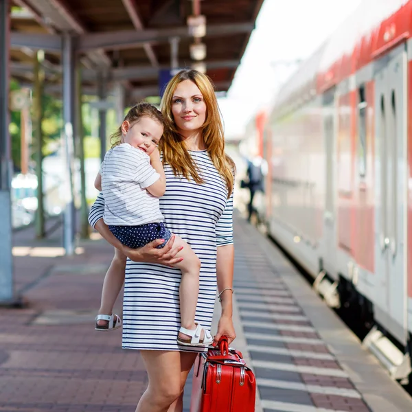 Linda niña y madre en una estación de tren . — Foto de Stock