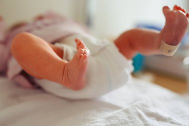 Yeni doğan çocuğun ayakları doğumdan saniyeler ve dakikalar sonra. Havluyla doğmuş küçük tatlı bir kız ya da erkek bebek. Yeni hayat, başlangıç, sağlık hizmetleri