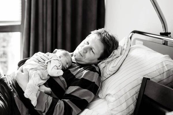 Yeni doğmuş bebeğini kucağında tutan mutlu bir baba. Şirin küçük bebek evde babasının göğsünde huzur içinde uyuyor. Aile sevgisi, bağlılık ve ebeveynlik kavramı