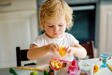 Evinde renkli kille sevimli, küçük bir kız. Sağlıklı bir bebek çocuk yuvasında ya da oyun okulunda hamur oynarken oyuncak yaratıyor. Kil kalıbı çıkaran küçük bir çocuk, yaratıcı aktivite.