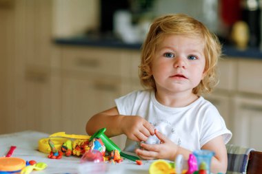 Evinde renkli kille sevimli, küçük bir kız. Sağlıklı bir bebek çocuk yuvasında ya da oyun okulunda hamur oynarken oyuncak yaratıyor. Kil kalıbı çıkaran küçük bir çocuk, yaratıcı aktivite.
