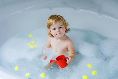 Çok sevimli şirin küçük yürümeye başlayan çocuk kız alma banyo küvet içinde. Kauçuk sakız oyuncaklar ile oynama ve eğlenerek mutlu sağlıklı bebek çocuk. Yıkama, temizlik, hijyen çocuklar için