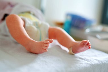 Yeni doğan çocuğun ayakları doğumdan saniyeler ve dakikalar sonra. Havluyla doğmuş küçük tatlı bir kız ya da erkek bebek. Yeni hayat, başlangıç, sağlık hizmetleri