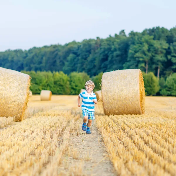 Маленький мальчик играет на сеновале, на открытом воздухе — стоковое фото