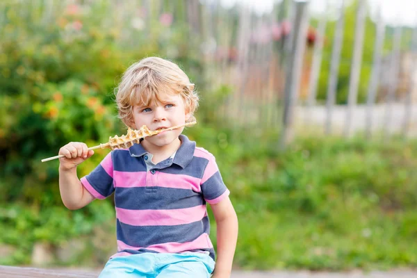 Carino biondo bambino ragazzo mangiare waffle su paglia — Foto Stock