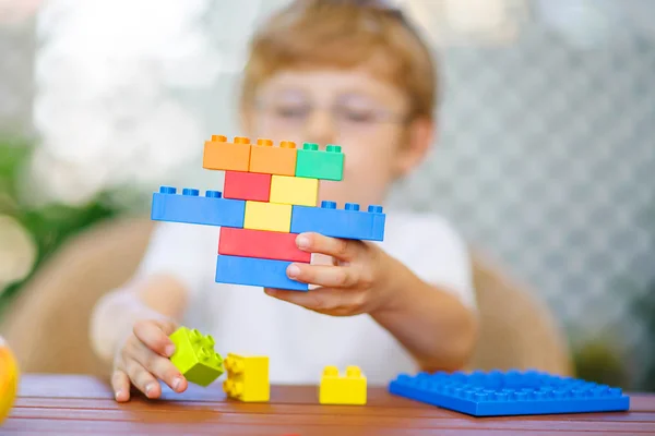 Маленький мальчик играет с пластиковыми блоками — стоковое фото