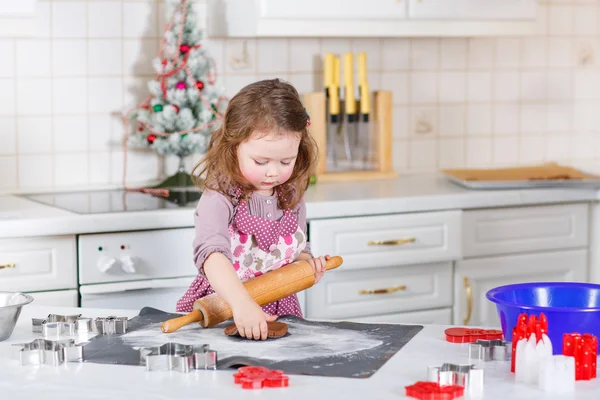 Menina fazendo biscoitos de gengibre na cozinha doméstica — Fotografia de Stock