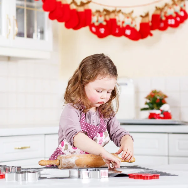 Malá holčička pečení perníku cookie v domácí kuchyni — Stock fotografie