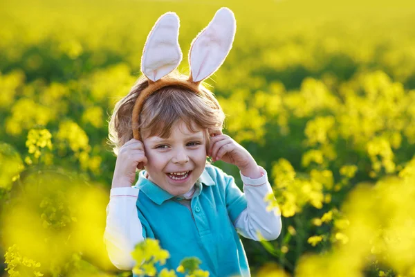 Lustiger Junge von 3 Jahren mit Osterhasenohren, der Ostern feiert — Stockfoto