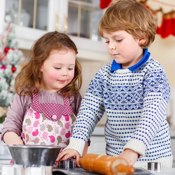 Garoto e menina fazendo biscoitos de Natal em casa — Fotografia de Stock