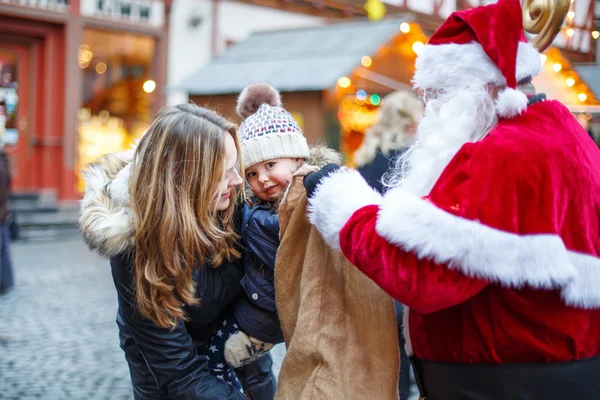 Niña con madre en el mercado de Navidad . —  Fotos de Stock