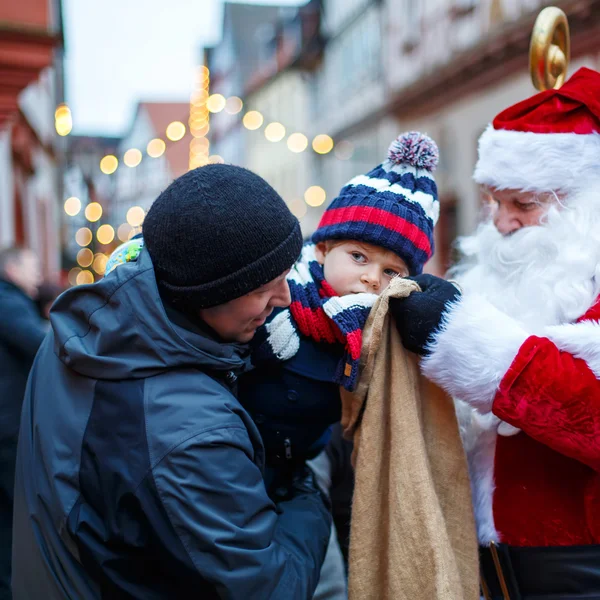 Pequeño niño con padre y Papá Noel en el mercado de Navidad — Foto de Stock