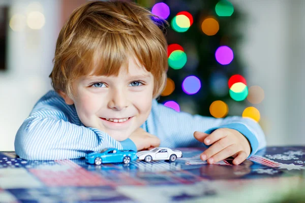 Маленька блондинка грає з машинами та іграшками вдома — стокове фото