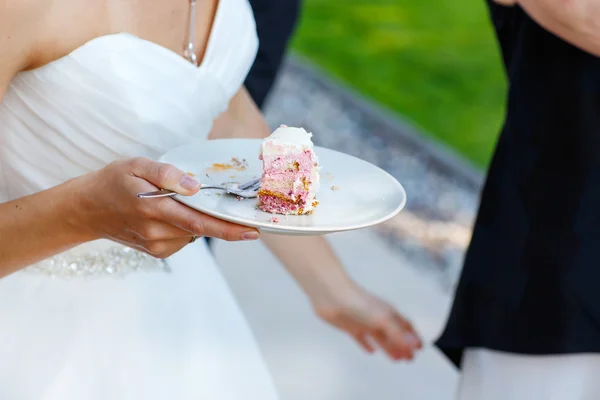 Braut hält leckere Hochzeitstorte in der Hand — Stockfoto