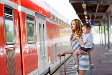 Sevimli küçük kız ve annesi bir tren istasyonu.