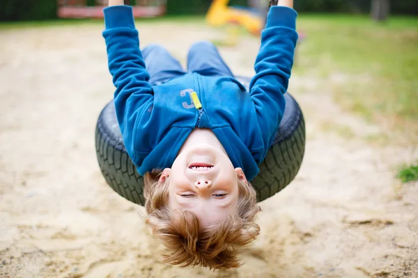 Little kid boy having fun on swing in summer — Stock fotografie