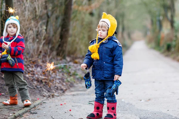 Two little children holding burning sparkler — Stock Photo, Image