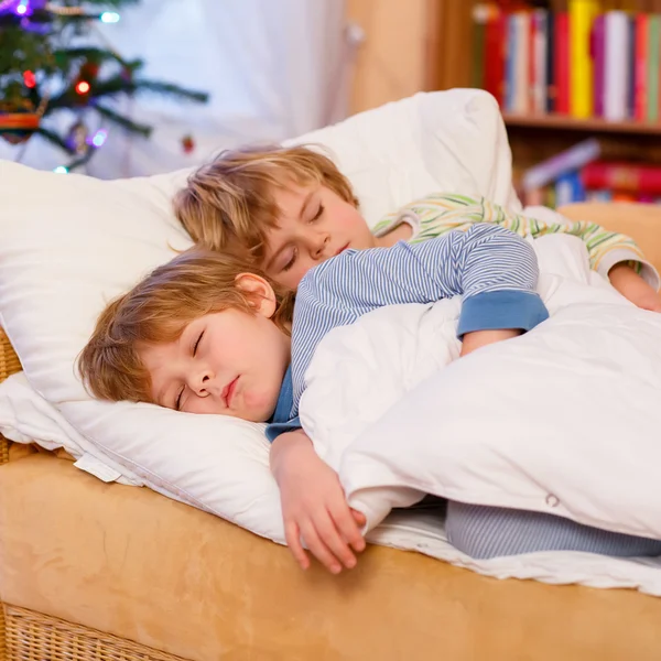 Dva malí chlapci blonďaté sourozence spí v posteli na Vánoce — Stock fotografie