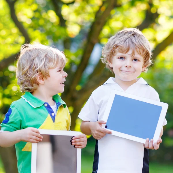 Dos niños pequeños divertidos feliz abount tabletas pc —  Fotos de Stock