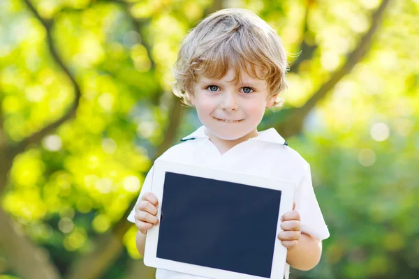 Niño preescolar con tableta pc, al aire libre —  Fotos de Stock