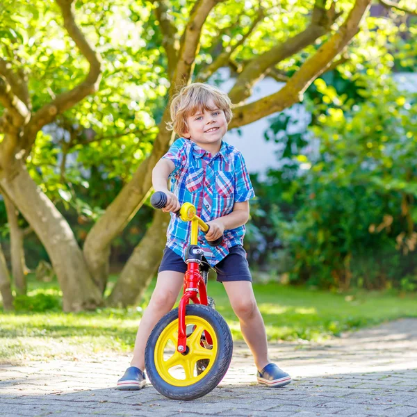 庭で三輪車や自転車を運転していた男の子を子供します。 — ストック写真