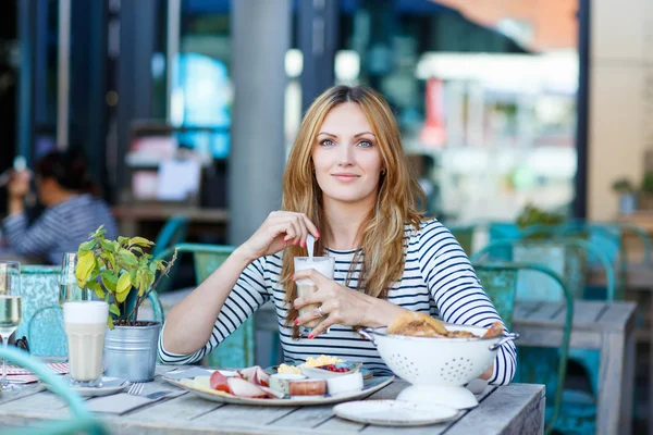 屋外カフェでヘルシーな朝食を持つ若い女性 — ストック写真
