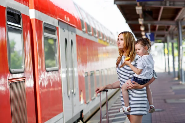 Linda niña y madre en una estación de tren . — Foto de Stock