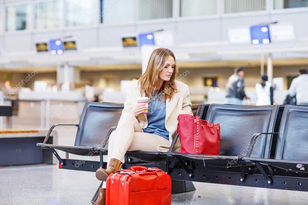 woman at international airport waiting for flight at terminal