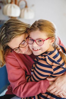 Küçük kızını kucaklayan mutlu bir anne. Sevimli mutlu okul çocuğu ve kadın.
