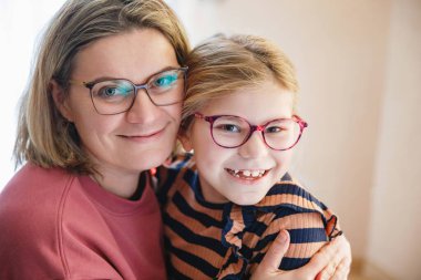 Küçük kızını kucaklayan mutlu bir anne. Sevimli mutlu okul çocuğu ve kadın.