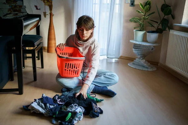 Yıkandıktan ve çamaşır yıkadıktan sonra çorapları sıralayan genç çocuk..