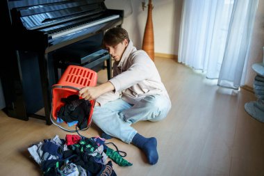 Yıkandıktan ve çamaşır yıkadıktan sonra çorapları sıralayan genç çocuk..