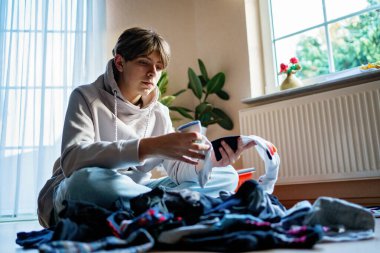 Yıkandıktan ve çamaşır yıkadıktan sonra çorapları sıralayan genç çocuk..