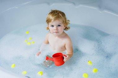 Çok sevimli şirin küçük yürümeye başlayan çocuk kız alma banyo küvet içinde. Kauçuk sakız oyuncaklar ile oynama ve eğlenerek mutlu sağlıklı bebek çocuk. Yıkama, temizlik, hijyen çocuklar için