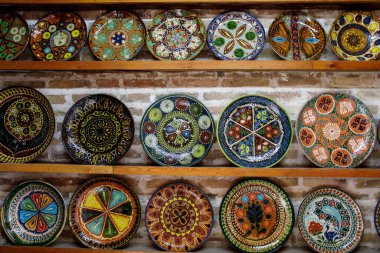 Buhara, Özbekistan 'da raflarda mavi süslemeli geleneksel Özbek seramik tabaklar, el yapımı dekoratif çömlek sanatı