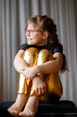 İçerde gözlük takan gülümseyen genç bir kızın portresi, doğal ışık, yumuşak odak, özgün çocukluk anı.