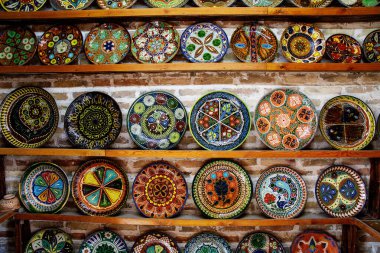 Buhara, Özbekistan 'da raflarda mavi süslemeli geleneksel Özbek seramik tabaklar, el yapımı dekoratif çömlek sanatı