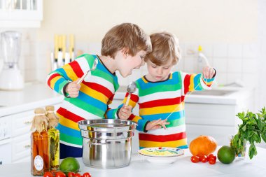 İki küçük çocuklar yerli mutfakta spagetti yiyen çocuk.