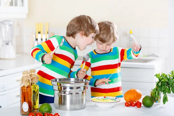 Zwei kleine Jungen essen Spaghetti in der heimischen Küche. — Stockfoto