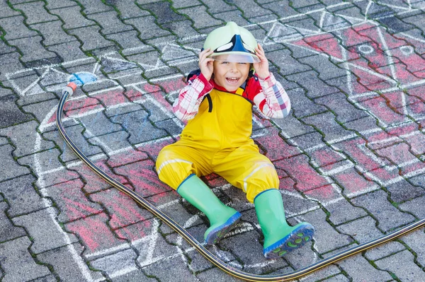 Lustiges, entzückendes Kind von vier Jahren hat Spaß mit Feuerwehrauto — Stockfoto