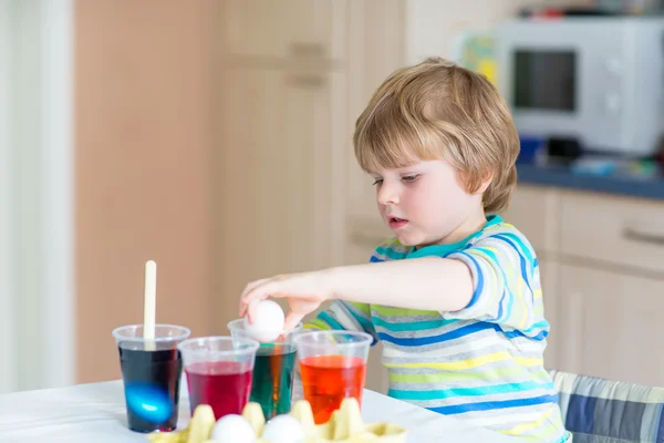 Kid jongetje kleuren eieren voor paasvakantie — Stockfoto