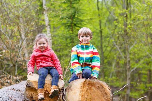 Κοριτσάκι και χαριτωμένο ξανθό αγόρι που παίζουν μαζί στο δάσος — Φωτογραφία Αρχείου