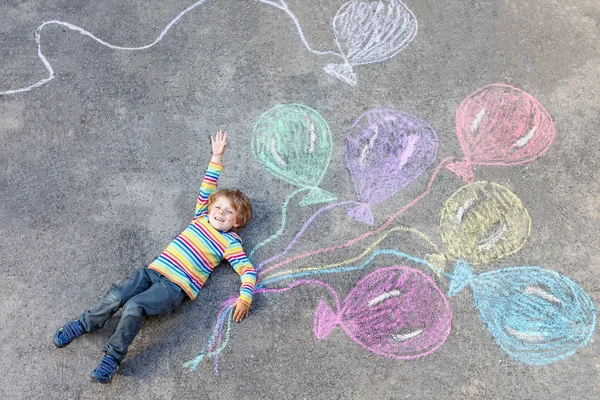 カラフルな風船で遊んでいる子供の男の子チョークで描く — ストック写真